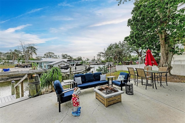 view of patio / terrace with a water view, a fire pit, and a boat dock