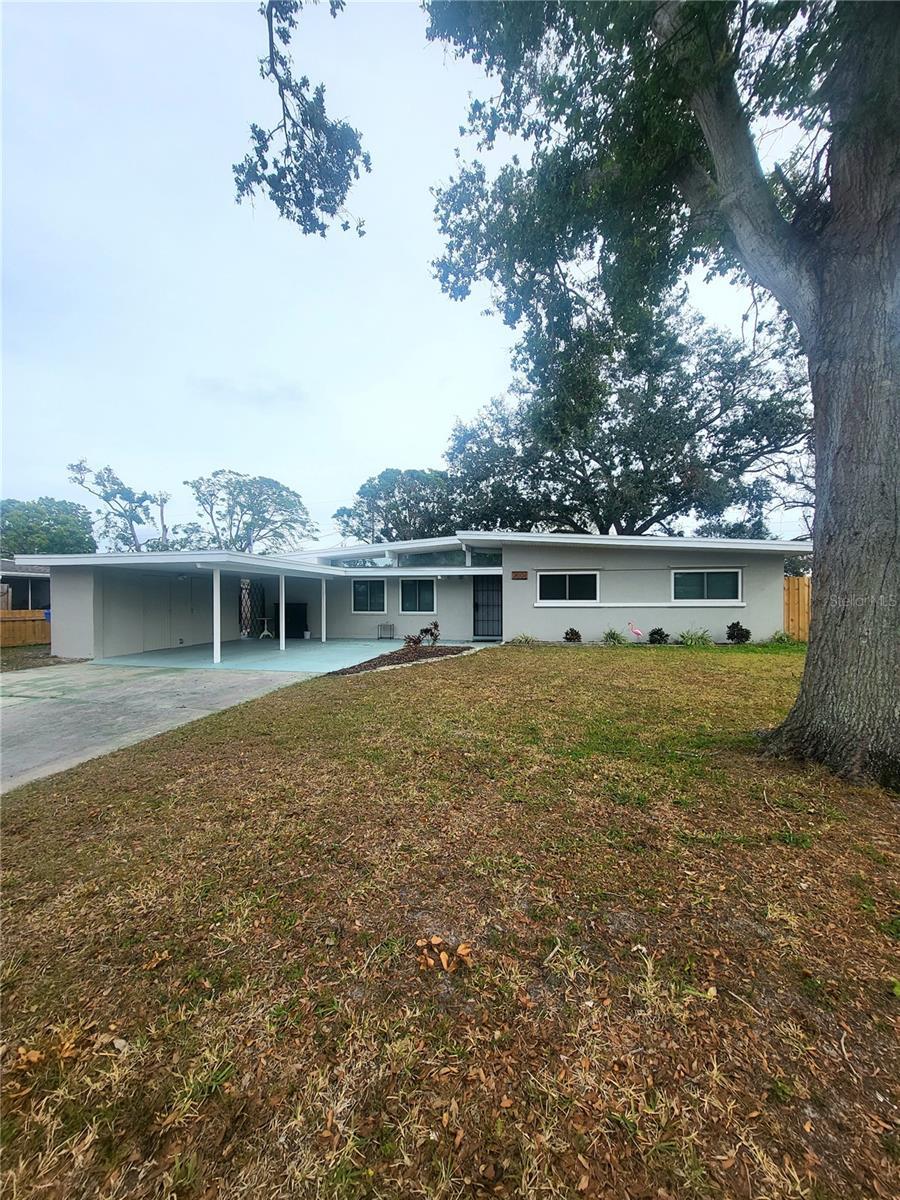 ranch-style house featuring a front yard and a carport