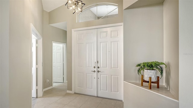 entryway featuring light tile patterned floors and a chandelier