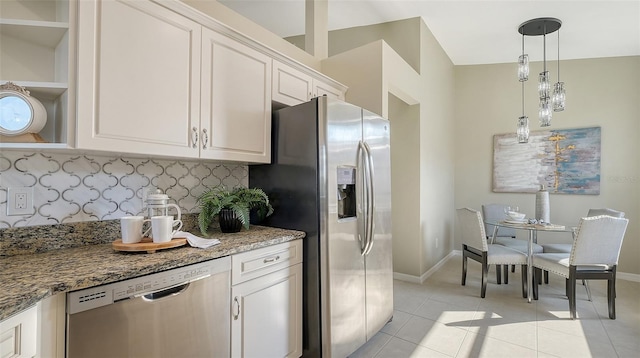 kitchen with stainless steel appliances, white cabinetry, light stone countertops, and light tile patterned flooring