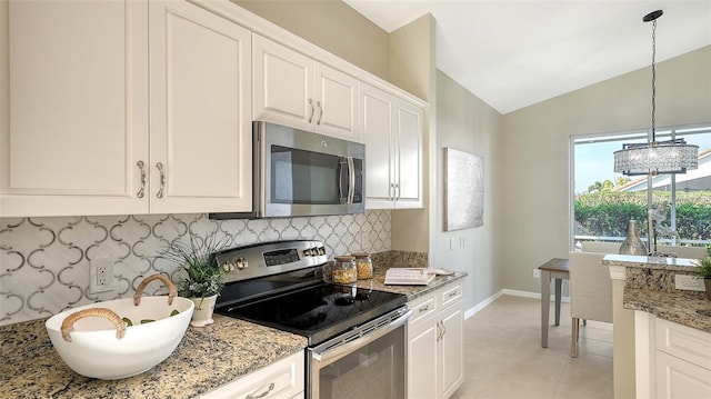 kitchen featuring appliances with stainless steel finishes, white cabinetry, lofted ceiling, decorative backsplash, and light stone counters