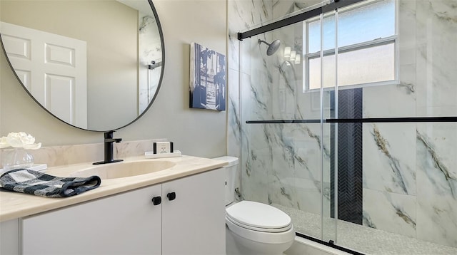 bathroom with vanity, toilet, and a shower with door