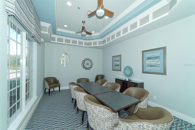 dining area with ceiling fan, ornamental molding, a raised ceiling, and carpet