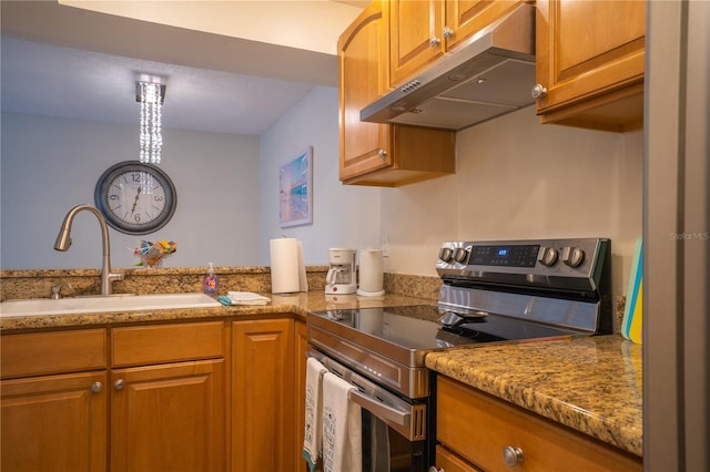 kitchen featuring light stone counters, sink, and stainless steel electric range oven