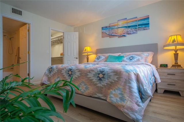 bedroom featuring a spacious closet, a closet, and light hardwood / wood-style floors