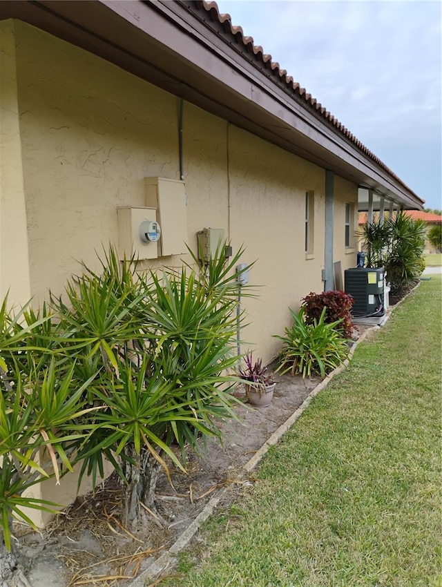 view of side of property with cooling unit and a yard