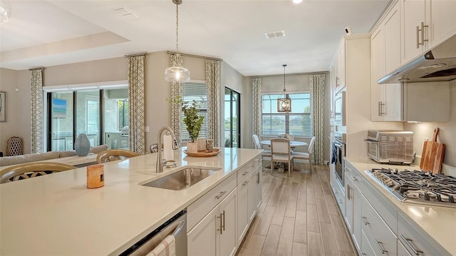 kitchen with white cabinets, hanging light fixtures, and sink