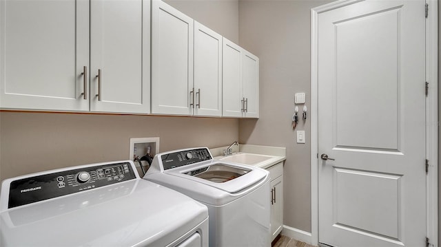 laundry room with sink, washer and dryer, and cabinets