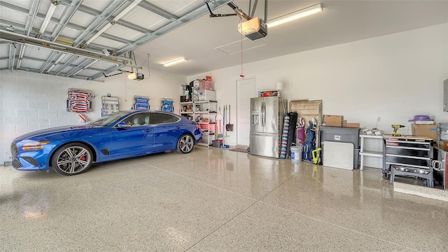 garage featuring stainless steel fridge with ice dispenser and a garage door opener