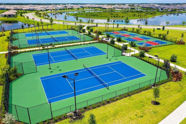 view of tennis court with a water view