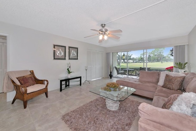 living area featuring ceiling fan and a textured ceiling