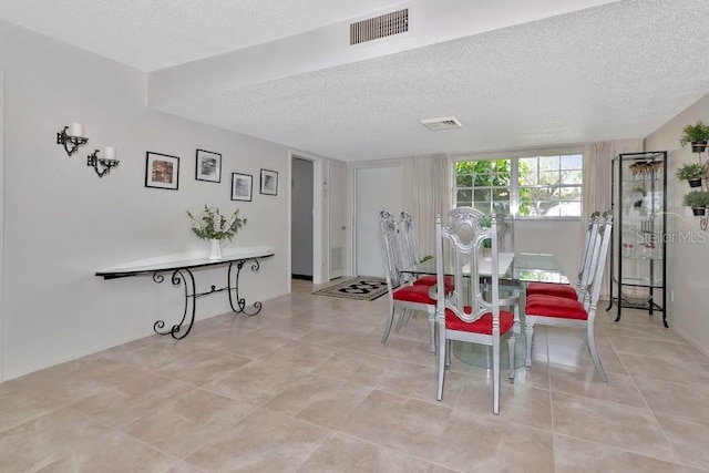 dining space featuring a textured ceiling and visible vents