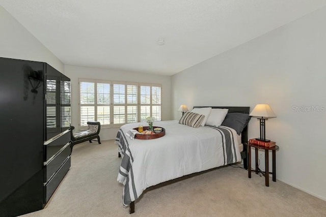 carpeted bedroom with lofted ceiling