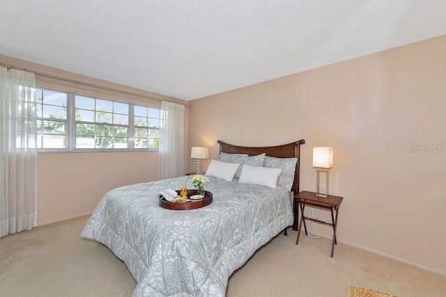 carpeted bedroom featuring a textured ceiling and baseboards