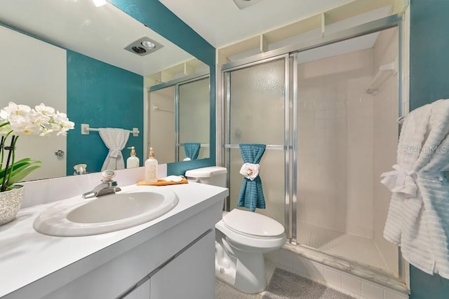 bathroom with tile patterned flooring, toilet, a shower stall, and vanity