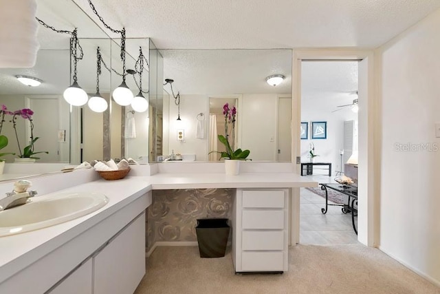 bathroom with a ceiling fan, a textured ceiling, and vanity