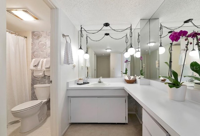 bathroom with a textured ceiling, vanity, and toilet