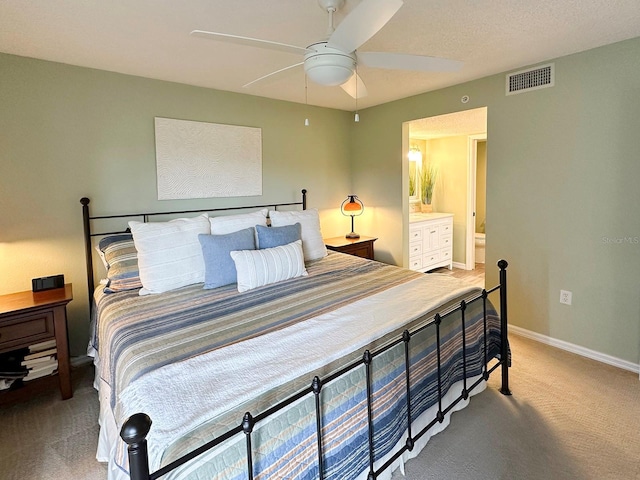 carpeted bedroom featuring ceiling fan and ensuite bath