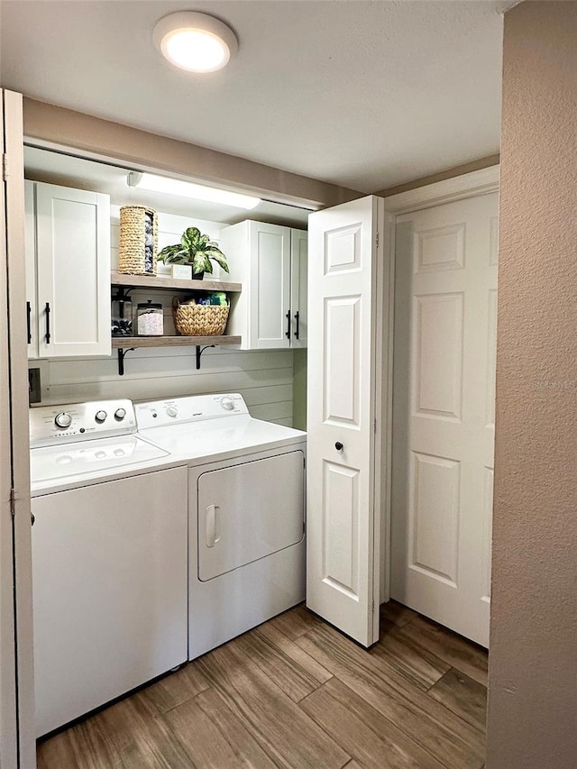 laundry area featuring cabinets, washer and clothes dryer, and light wood-type flooring