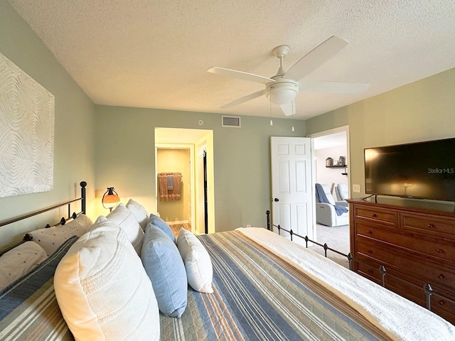 bedroom featuring ceiling fan, a textured ceiling, and carpet floors