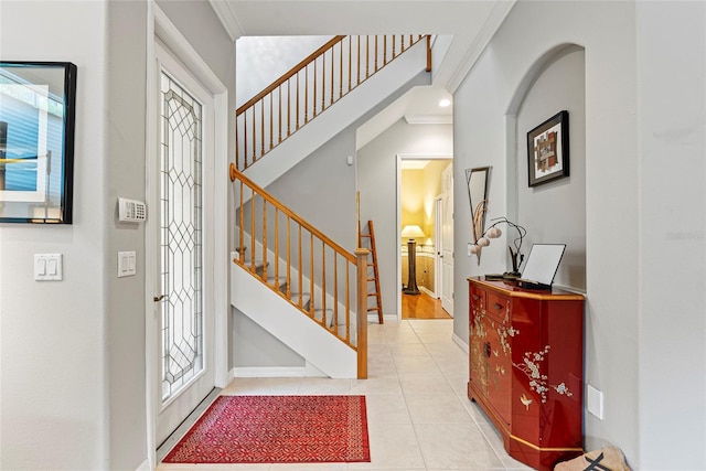 tiled entryway featuring crown molding