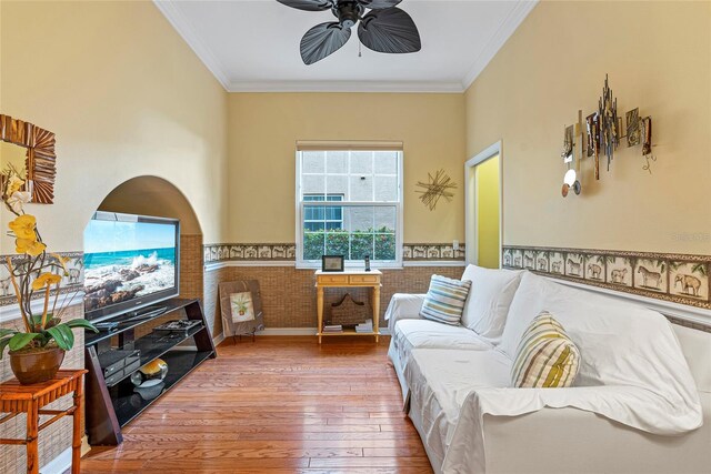 living room featuring ceiling fan, wood-type flooring, and ornamental molding