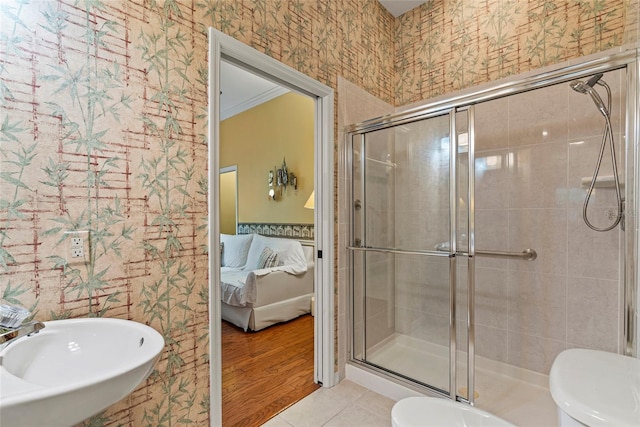 bathroom with sink, toilet, ornamental molding, and tile patterned flooring