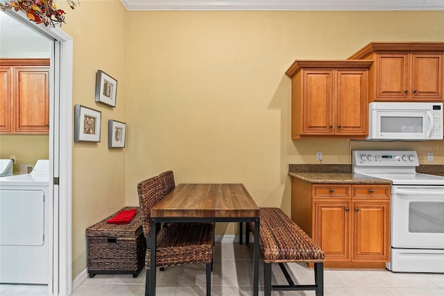 kitchen with washer and dryer, crown molding, light tile patterned flooring, and white appliances