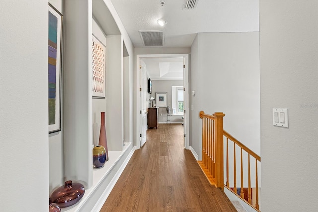 corridor featuring a textured ceiling and wood-type flooring