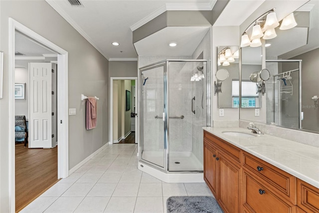 bathroom featuring vanity, a shower with door, tile patterned floors, and crown molding