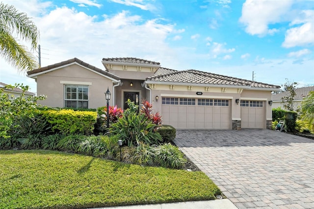 mediterranean / spanish-style home with a garage and a front lawn