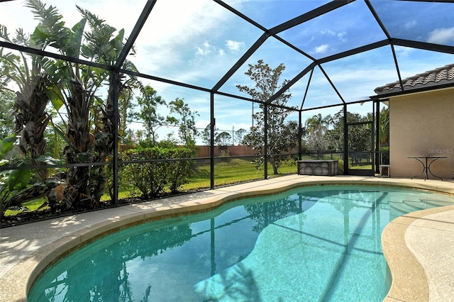 view of pool with a jacuzzi, a patio area, and glass enclosure