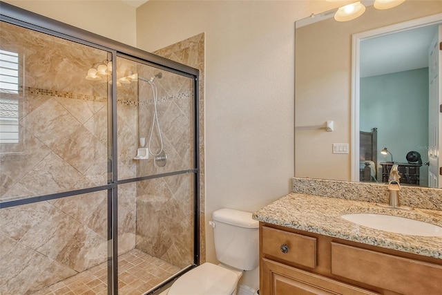 bathroom featuring vanity, toilet, and a shower with shower door