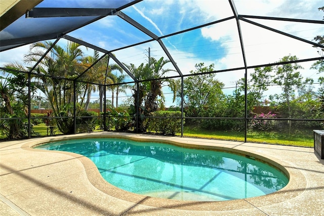 view of pool with a patio area and glass enclosure