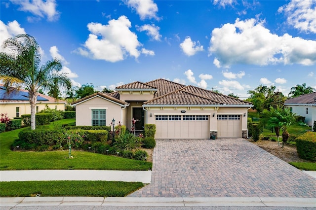 mediterranean / spanish-style house featuring a garage and a front lawn