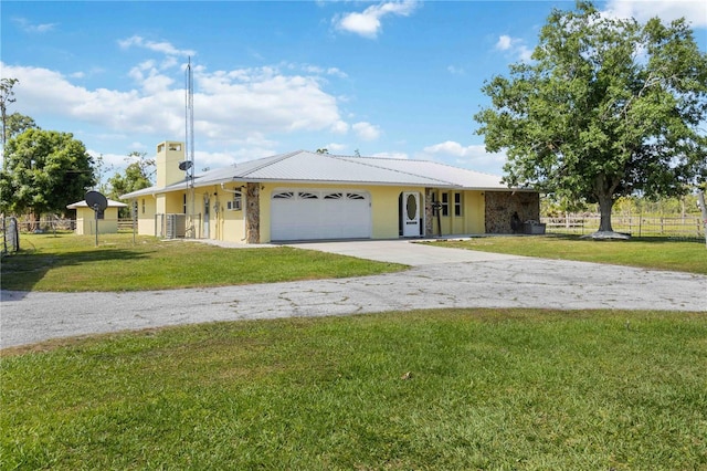 single story home featuring a front yard, central AC unit, and a garage