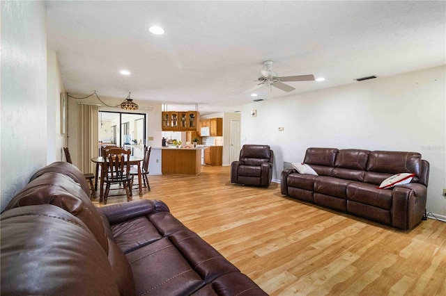 living room featuring ceiling fan and light hardwood / wood-style flooring