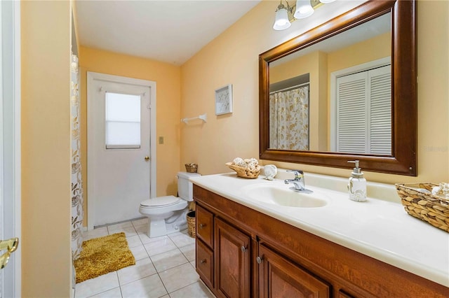 bathroom with toilet, tile patterned floors, and vanity