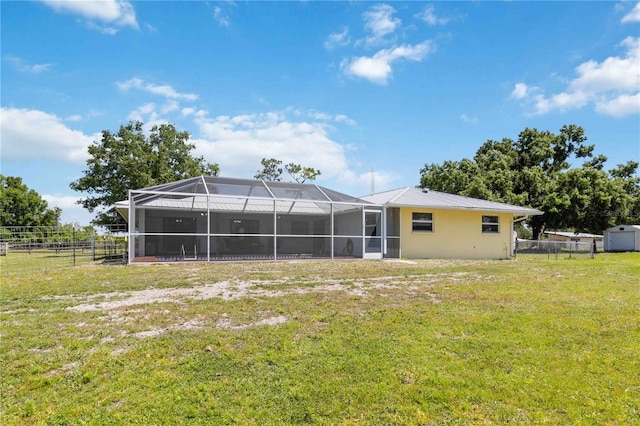 rear view of property featuring a lanai, a lawn, and a storage shed