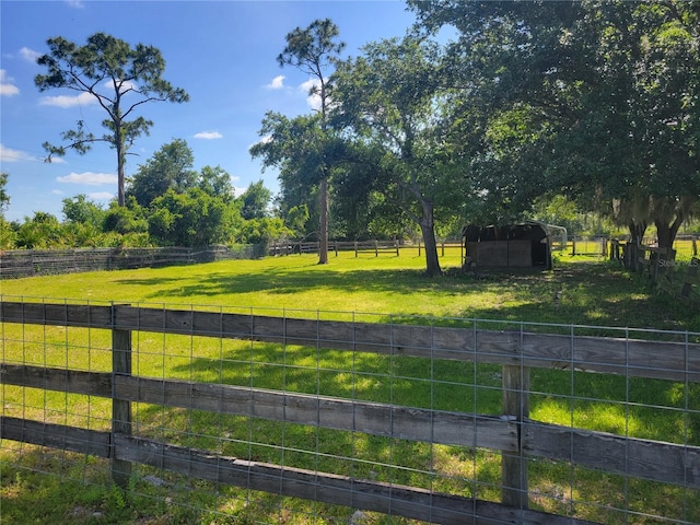 exterior space featuring a rural view and a yard