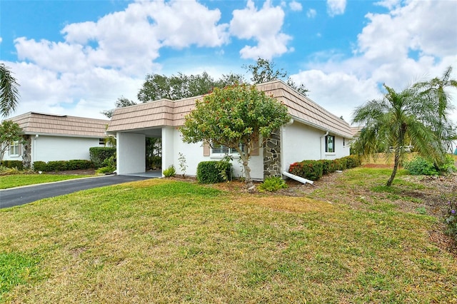 view of front of property with a front lawn and a carport