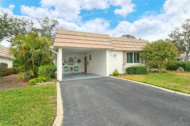 view of front of property with a front lawn and a carport