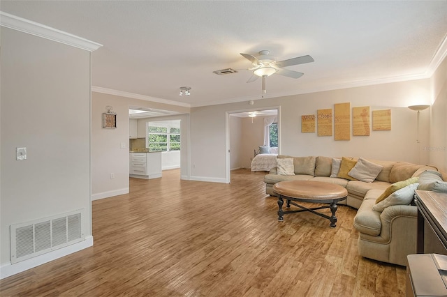 living room with ceiling fan, crown molding, and light hardwood / wood-style floors