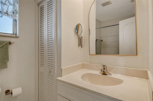 bathroom featuring a shower and vanity