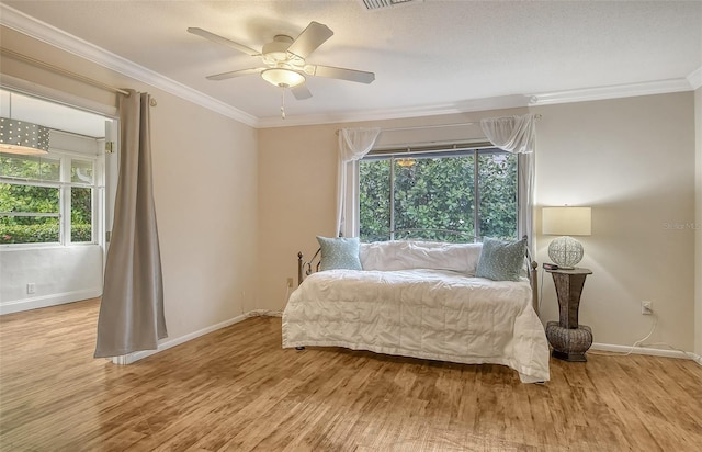 bedroom featuring ceiling fan, light hardwood / wood-style floors, and ornamental molding