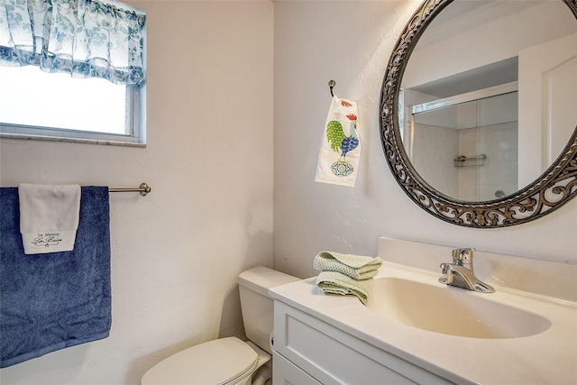 bathroom with a shower with door, toilet, and vanity