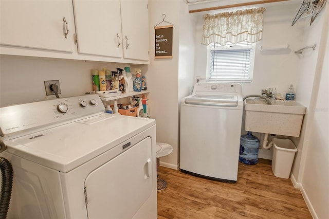 washroom with cabinets, washer and clothes dryer, light hardwood / wood-style flooring, and sink