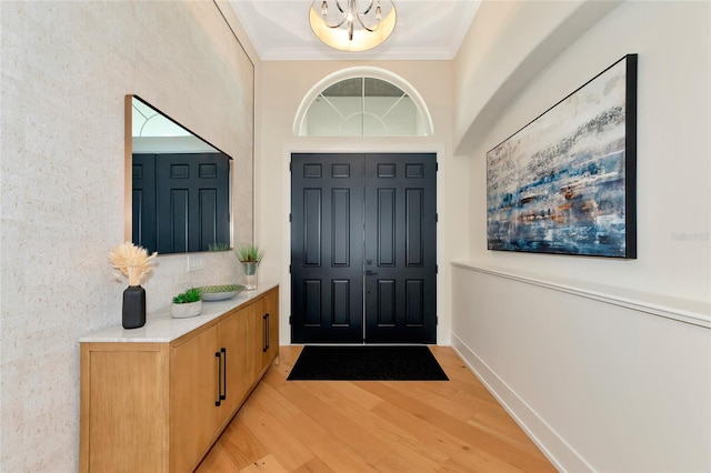 entryway featuring ornamental molding and light hardwood / wood-style flooring