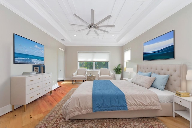 bedroom with ceiling fan, light hardwood / wood-style floors, ornamental molding, and a raised ceiling