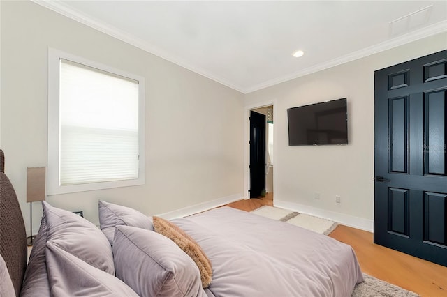 bedroom with crown molding and light hardwood / wood-style floors